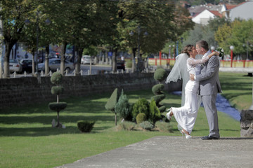 bride and groom kissing beside a small river in the city