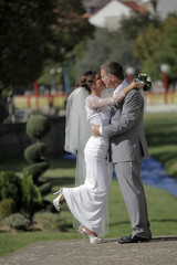 bride and groom kissing beside a small river in the city