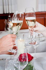 Paar sitzt lachend im Restaurant anstoßen mit Sekt