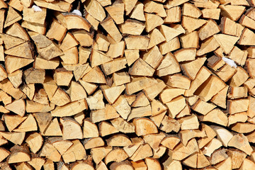 Stock of firewood for a fireplace in the is put on a backyard