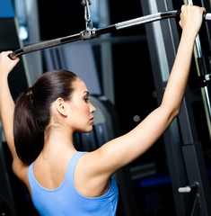 Fototapeta na wymiar Athletic kobieta pracuje obecnie na symulatorze w siłowni