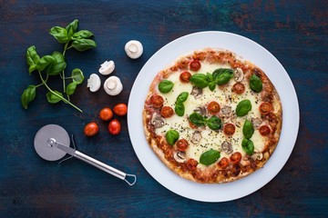 Pizza with mushrooms, tomatoes and basil