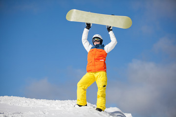 female snowboarder against sun and blue sky