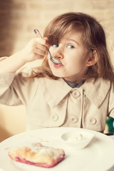 happy little girl indoors eating and smiling