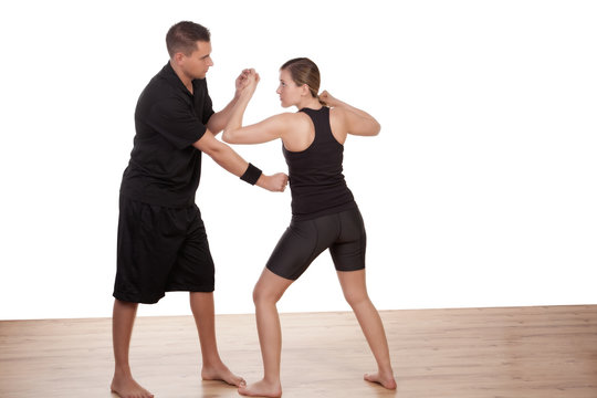 Instructor teaching a woman kick boxing