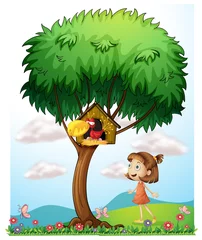 Poster Een meisje in de tuin met een vogel in een vogelhuisje © GraphicsRF