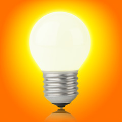Glowing incandescent bulb on yellow-orange with clipping path