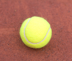 Tennis ball close up on red ground