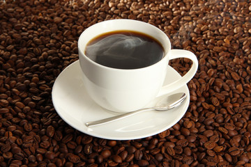 Cup of coffee on coffee beans background