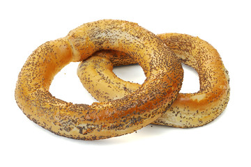 Bagels covered with poppy seeds on white background.