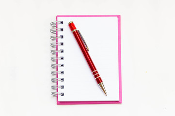 pink notebook with red pen on white background