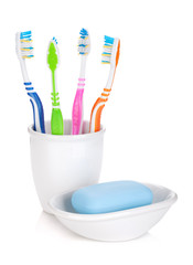 Four colorful toothbrushes and soap