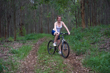 Naklejka premium Active girl woman in forest with mountain bike
