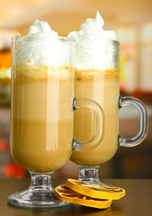 Fragrant coffee latte in glasses cups with dry orange,