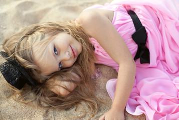 Naklejka premium Beautiful little girl in a pink dress walking