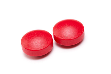 Two red aspirin isolated on a white background