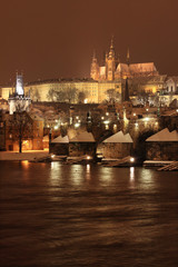 Fototapeta na wymiar Night colorful snowy Prague gothic Castle with Charles Bridge