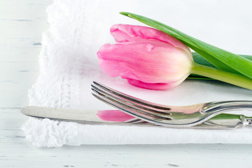 Closeup of pink tulip at rustic dinner setting