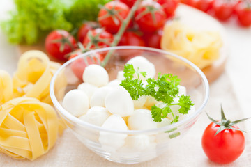 mozzarella in a transparent bowl and raw fettuccine