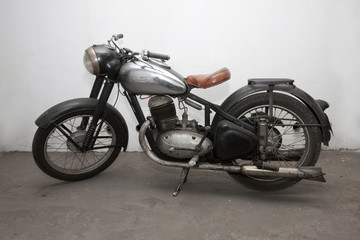 a standing black and silver veteran motorbike