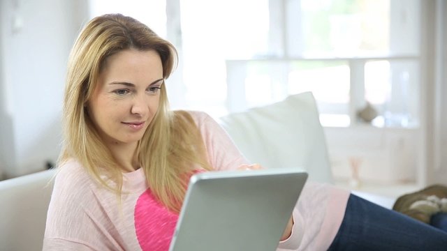35-year-old woman websurfing with tablet