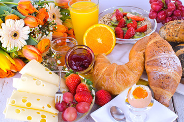 Frühstück mit Obst, Käse, Ei, Brötchen, Croissants ...