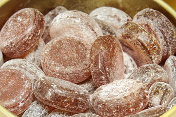 tin filled with hard candy of cola dusted with powdered sugar