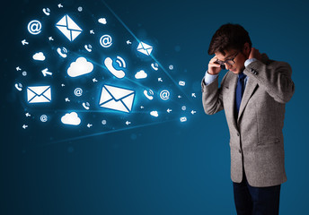 Young man making phone call with message icons