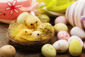 decorative chicken in  a nest with easter eggs background