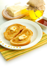 White bread toastwith honey on plate, isolated on white