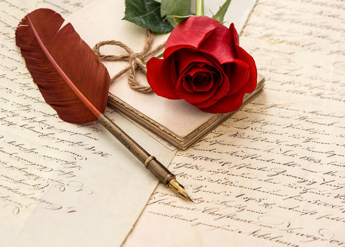 red rose flower, old letters and antique feather pen