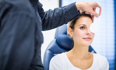 Optometry concept - pretty young woman having her eyes examined