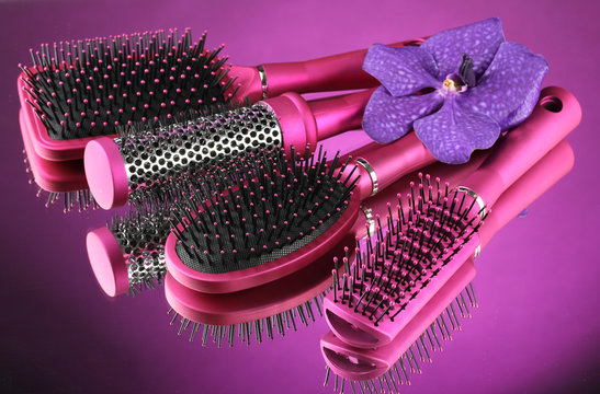 Comb brushes and flower on purple background