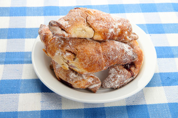 Taste croissants on plate, on tablecloth.
