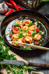 Fried shrimps on pan with fresh herbs