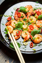 Closeup of shrimps with herbs on pan