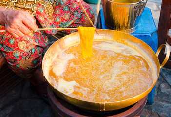 old women making Thai dessert made from duck egg yolks and sugar