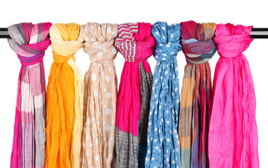 Many bright female scarfs isolated on white
