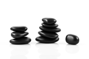 Black massage stones stacked, isolated.