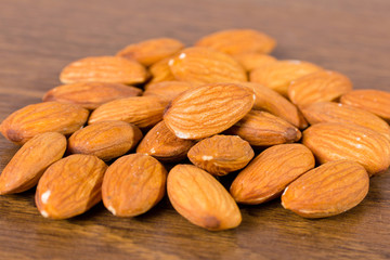 nuts of almond are on a wooden surface