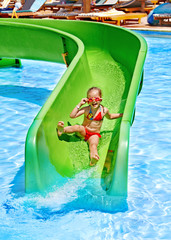 Child on water slide at aquapark.