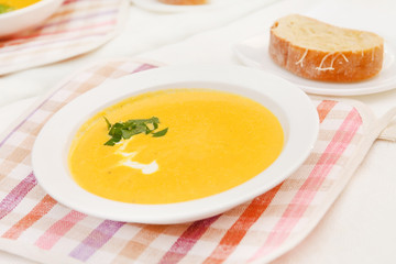 Pumpkin soup in white bowl