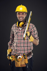 Smiling construction worker holding measuring