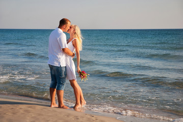 Couple on summer sea beach hug one another and kissing © EMrpize