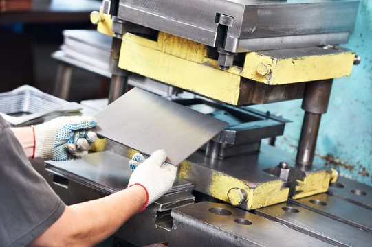 worker operating metal sheet press machine