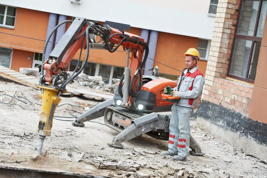 builder worker operating demolition machine