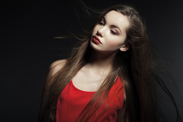 Fototapeta premium Portrait of a beautiful young woman in a red dress.