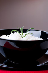 Cooked Rice in black bowl  with red napkin