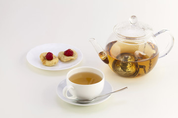 A cup of tea, candied fruits and teapot