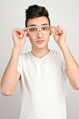 Surprised, amazed, wondering.Young man with funny glasses.